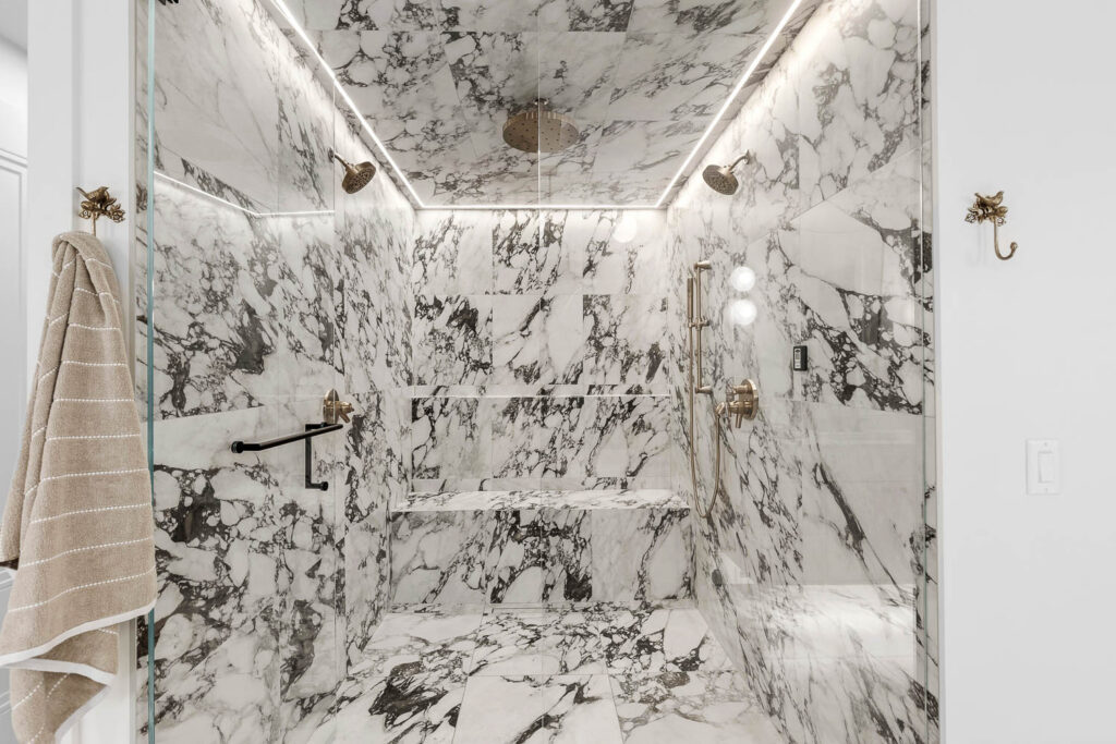 Large tiled shower with bench and dual shower fixtures