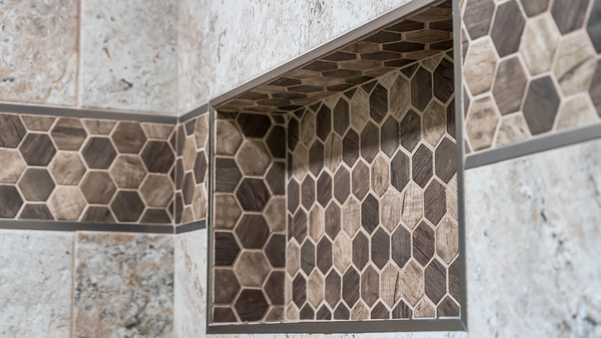 Tiled shower niche with mosaic accent tile holding bottles